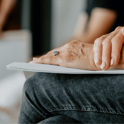 A person's hand on a piece of paper in a meeting